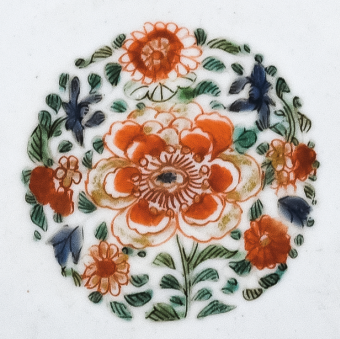 圖為清代五彩花卉紋碟細(xì)節(jié)圖，碟心主題紋飾為團(tuán)花圖，紅花綠葉，相映成趣。（來源：廣州十三行博物館）
